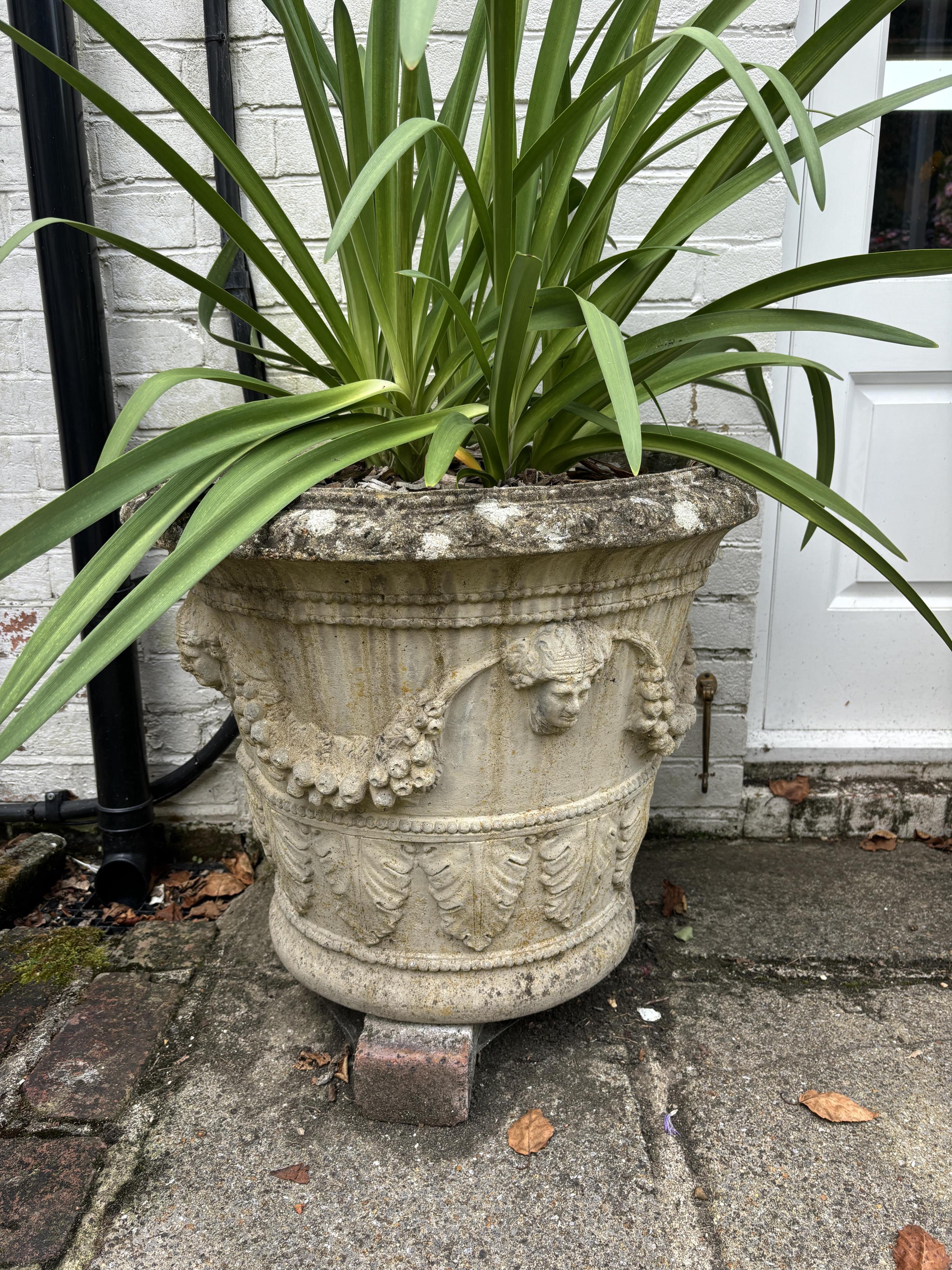 A pair of circular reconstituted stone garden urns, height 50cm, depth 60cm. planting removed. Condition - weathered otherwise good